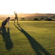 Golf player at top of backswing after physio for low back pain from golf.