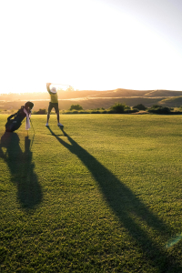 Golf player at top of backswing after physio for low back pain from golf.