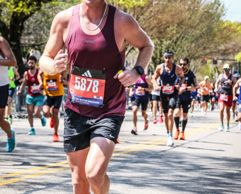 Close-up of a runner showing proper running form and cadence while going uphill.