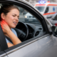 Woman holding neck in pain after a car accident, common presentation of whiplash injury